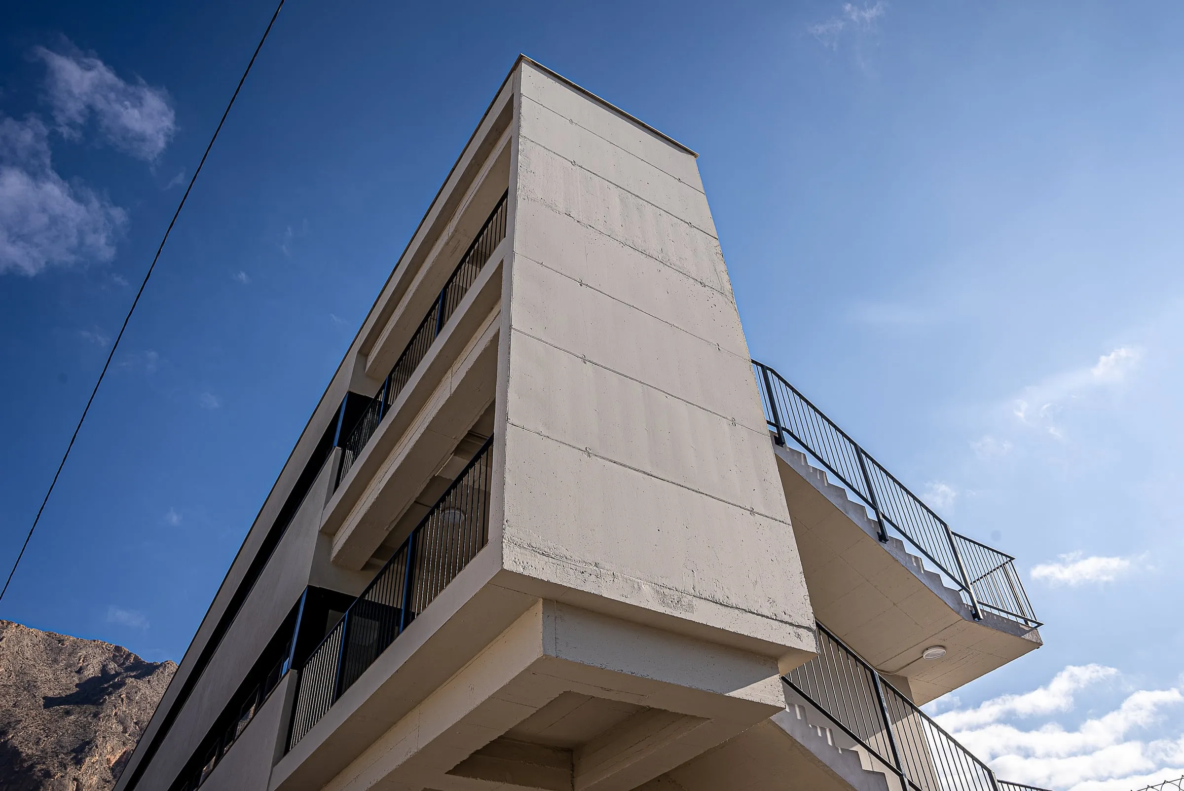 Voladizo de la escalera exterior de la ampliación del IES Jaime de Sant Àngel, en Redován, recortado contra el cielo
