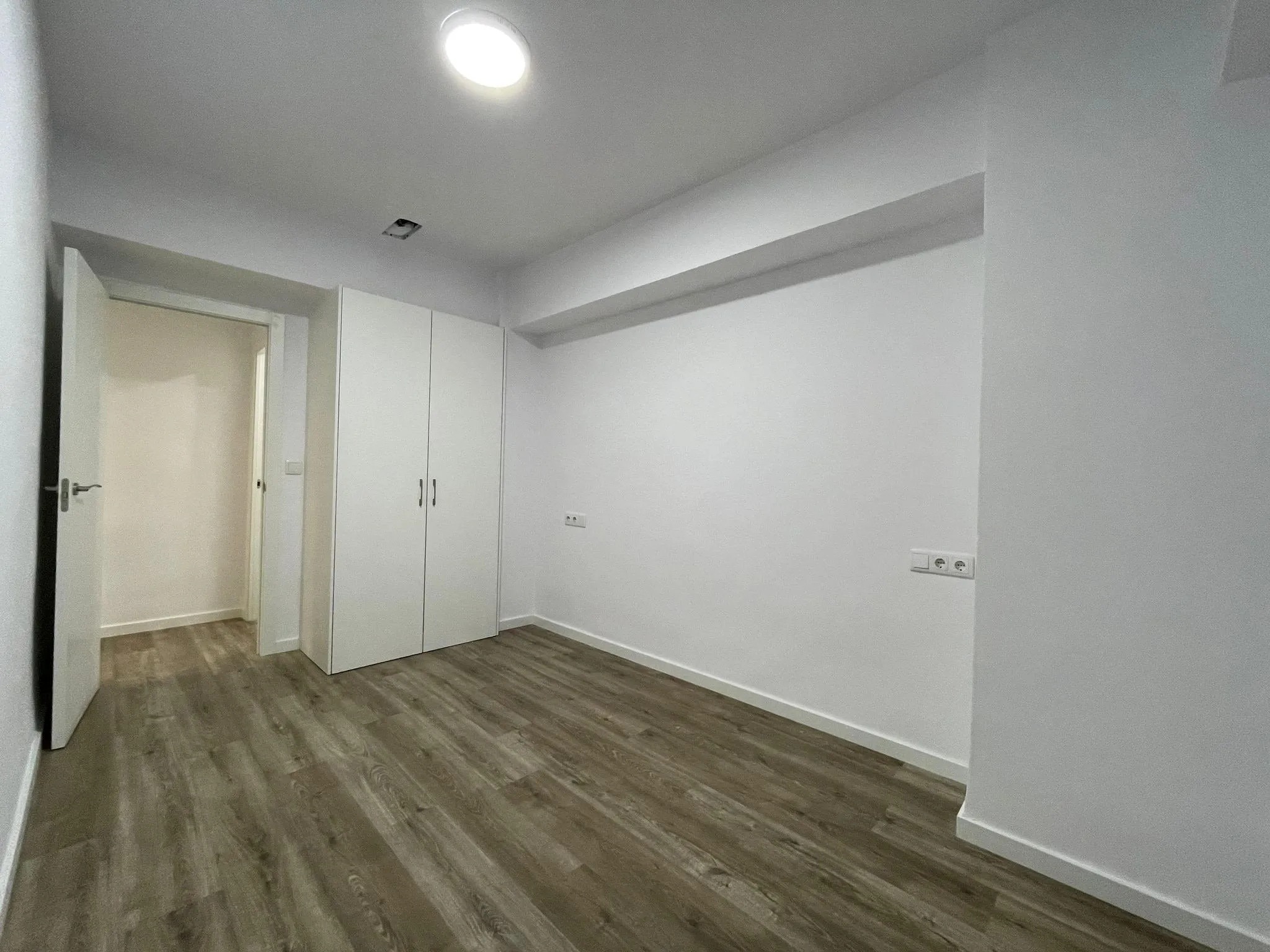 Dormitorio con puertas blancas y suelo laminado